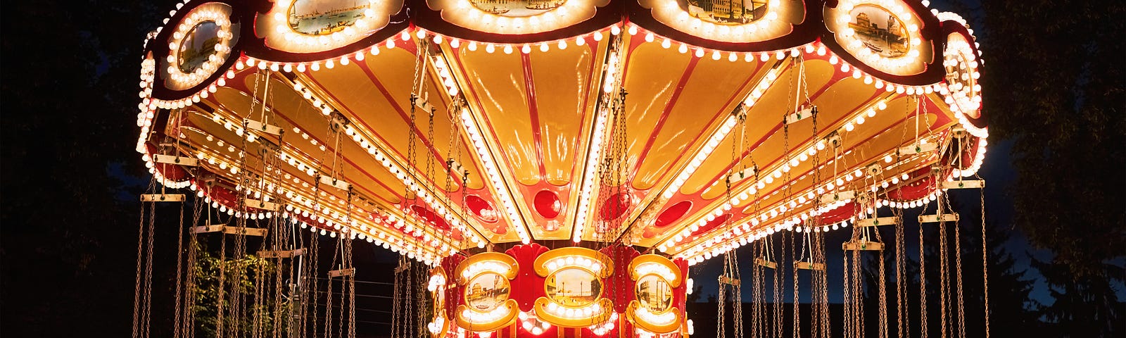 A carousel at night, glowing an ominous gold light in the midst of darkness.