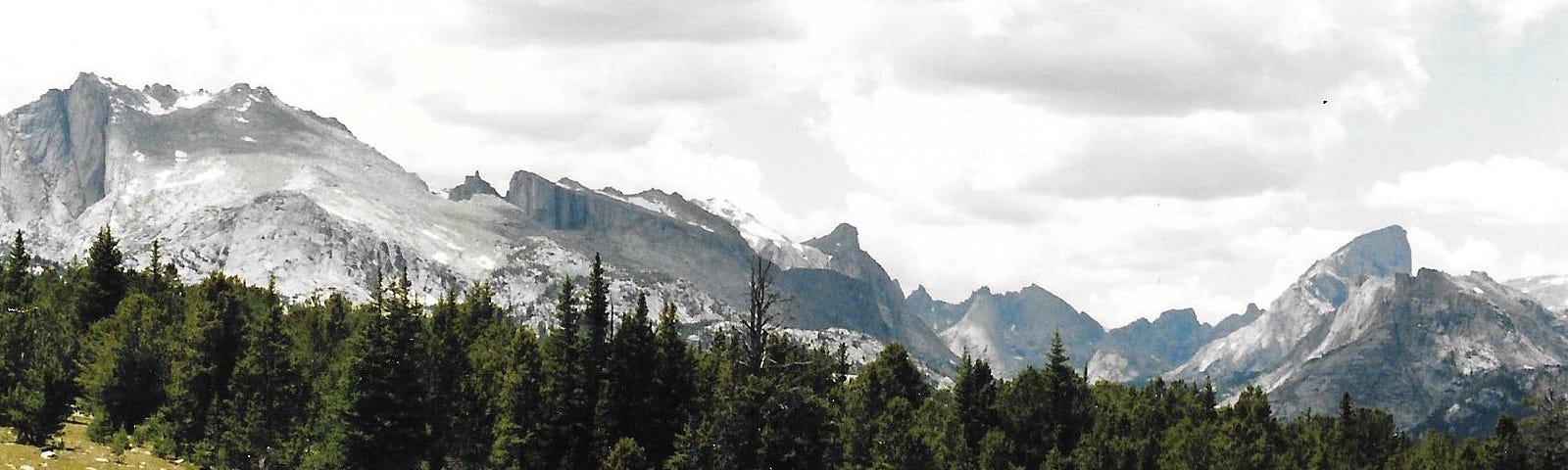 Backpackers walking up Pinto Park Pass in the Wind River Mountains with the Cirque of the Towers in the background.