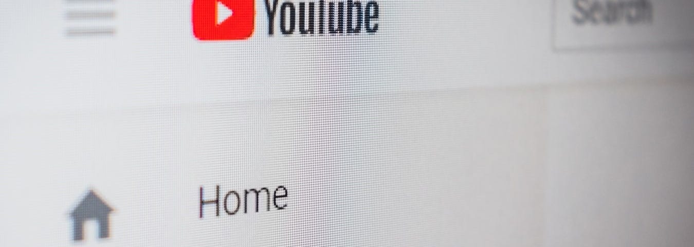 Close-up of YouTube’s landing page showing the YouTube logo as well as the “Home” and “Trending” buttons.