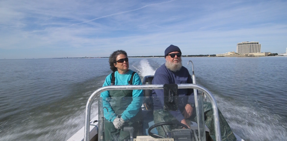 Oyster farmers piloting a boat in the Gulf of Mexico.