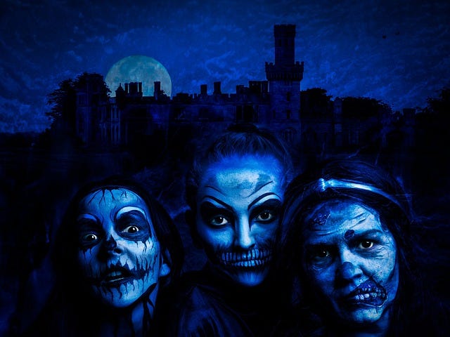 three witches, ghoulish face paint, nights sky and castle in background, blue edit