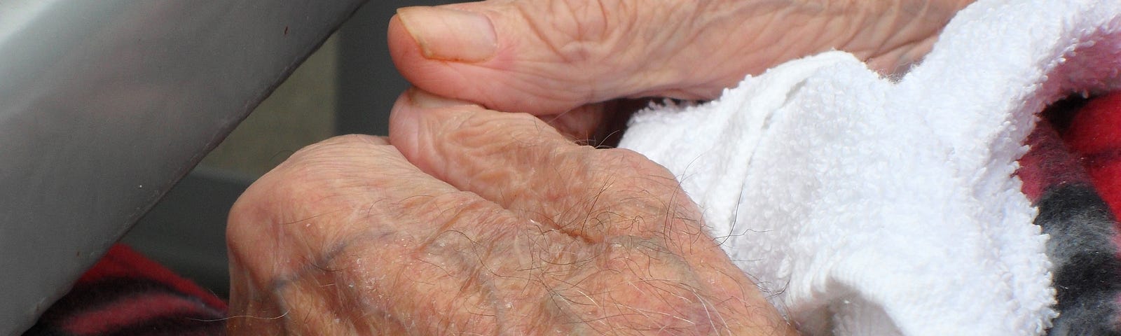 elderly man’s hands in his lap