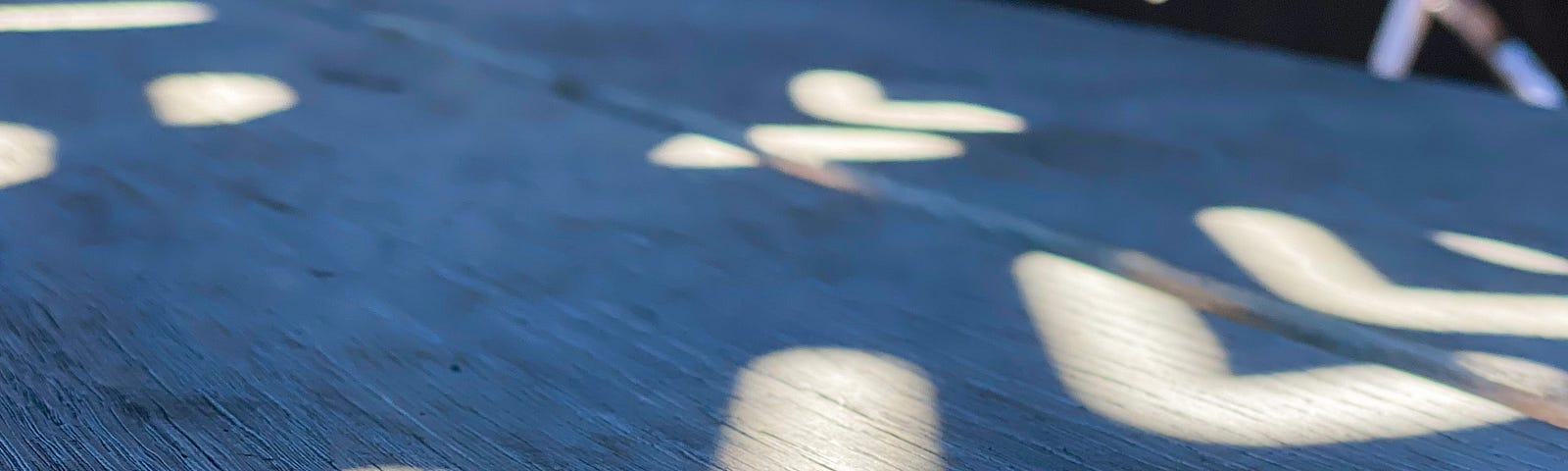 Shadow still life composition of an art installation casting shadows in a geometric pattern on a bench © pockett dessert