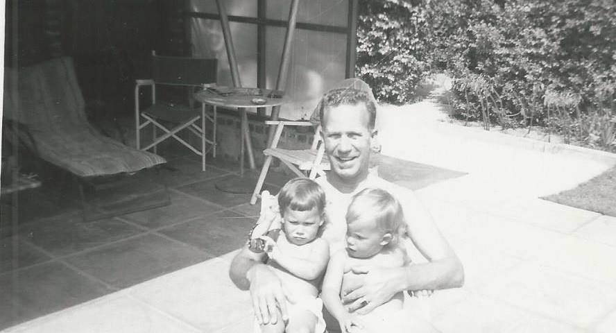 black and white photo of man cuddling two little kids in the summer. Phobia