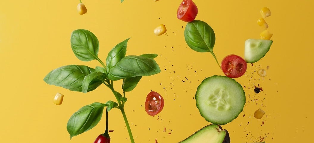 Some health foods, tomatoes, basil, avocado, cucumber and sweet corn.