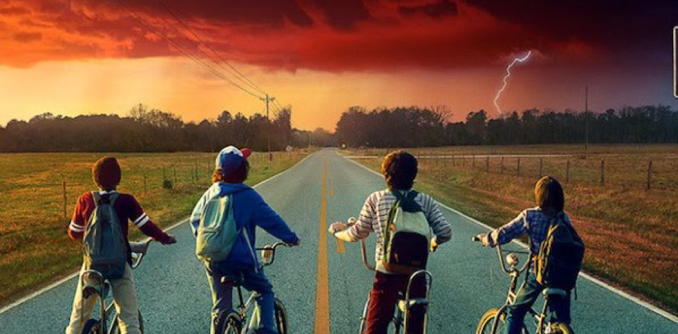 Kid on bikes looking out at a stormy horizon.