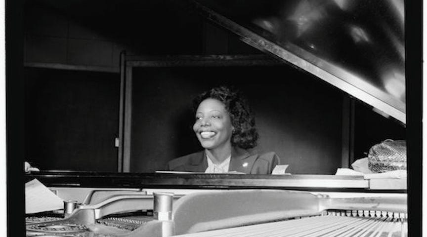 Jazz pianist Mary Lou Williams sitting at a grand piano / B & W