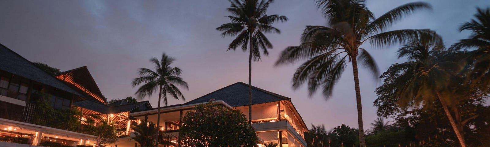 A fancy mansion with a swimming pool and palm trees.