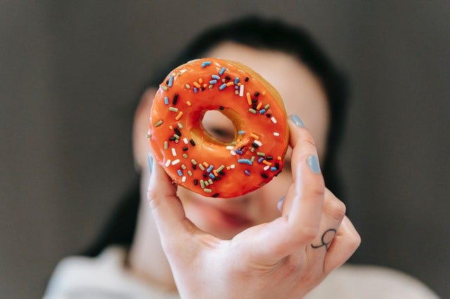 woman looking through a doughnut hole