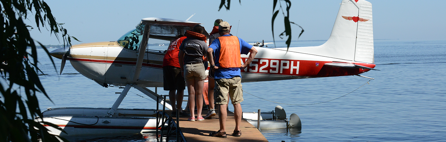 Photo of a floatplane at the dock with people borading.