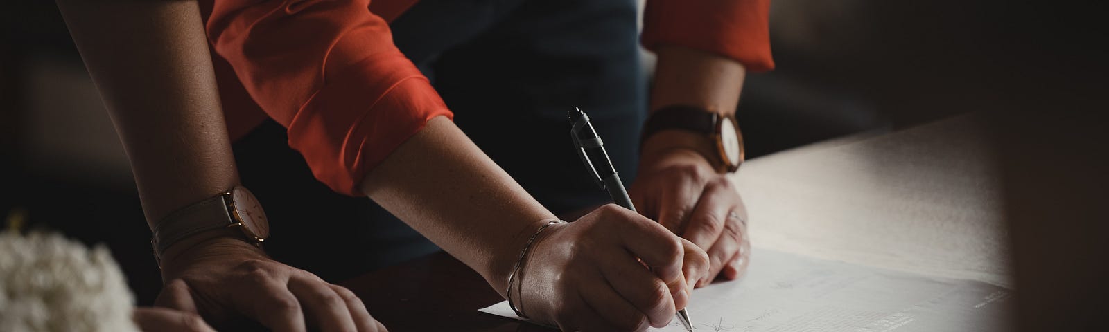 Two persons signing and verifying documents as an illustration for the  Cosign-Connaisseur interplay for container image verification in Kubernetes.