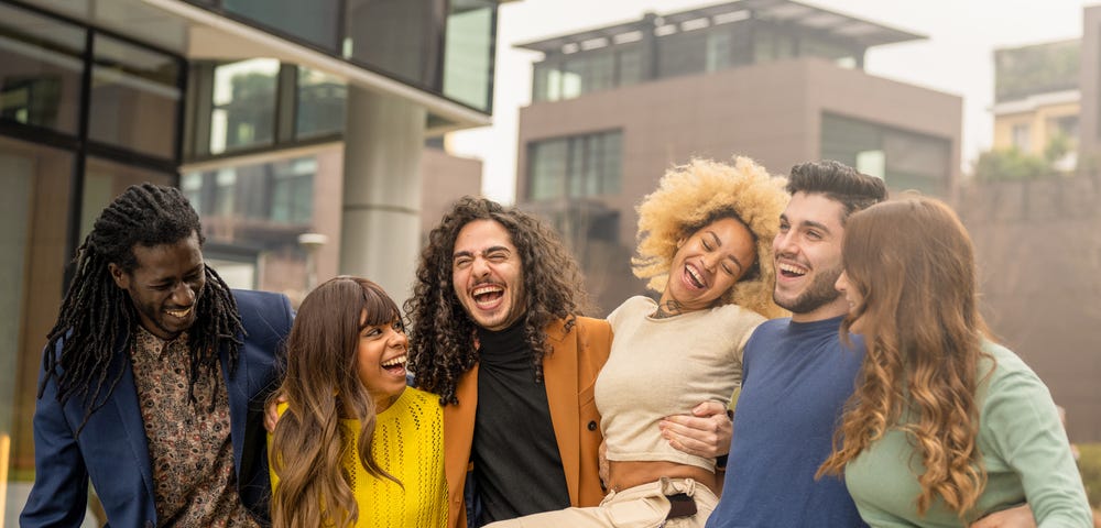 multiracial group of friends walking and having fun together, millennials people smiling and laughing in city context, social diversity people from the world