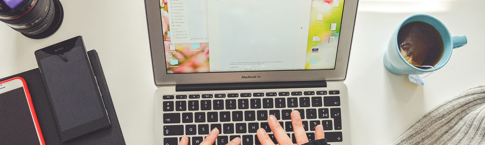 Writer at a computer wearing black fingerless gloves