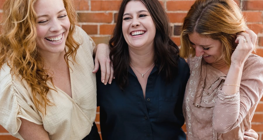 Photo of women laughing and enjoying each other.