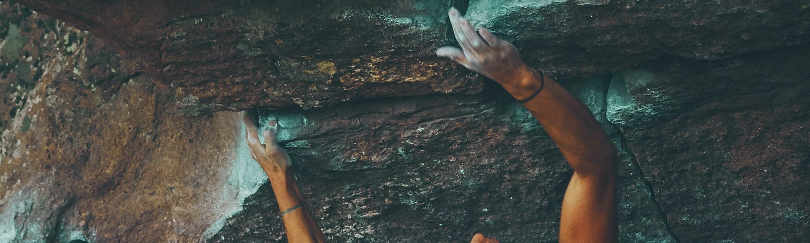 A woman scaling a rock face