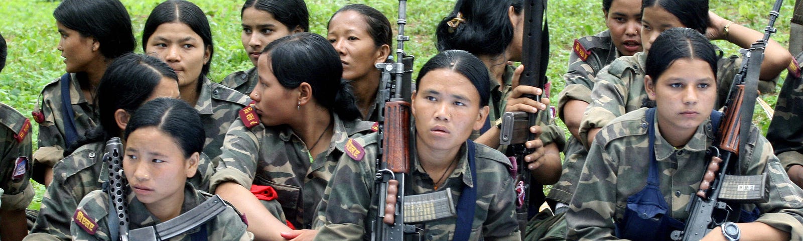 Nepalese Maoist rebels sit in a group with their weapons.