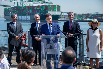 Secretary Buttigieg delivers remarks behind a podium at the Port of Los Angeles.