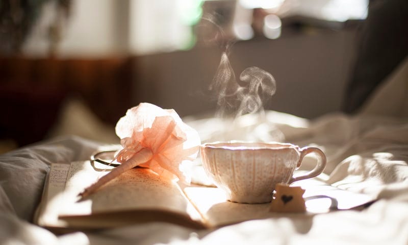 A hot cup of coffee on top of a diary