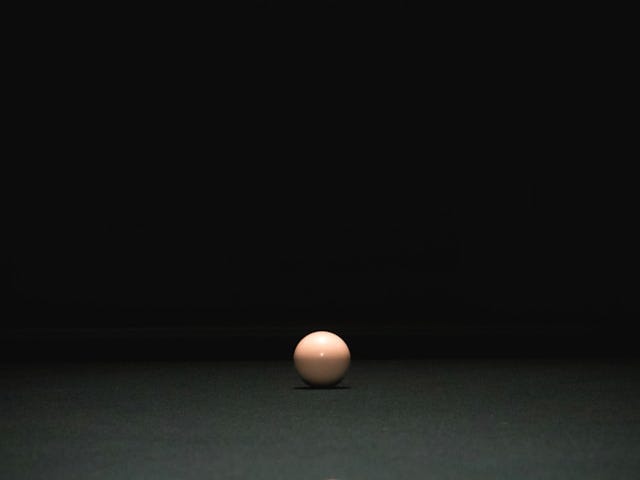 Colorful balls set up on a pool table; the white ball is prepared for the shot.
