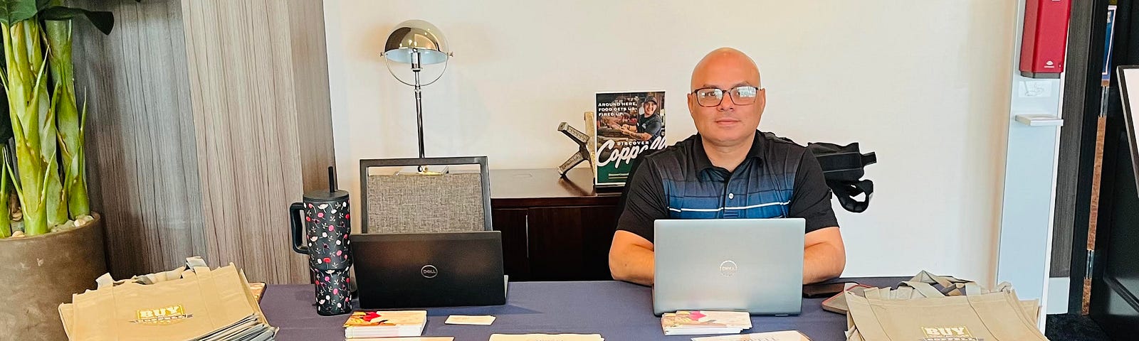 Luay Rahil sitting behind a table while hosting a job fair at the city of Coppell.