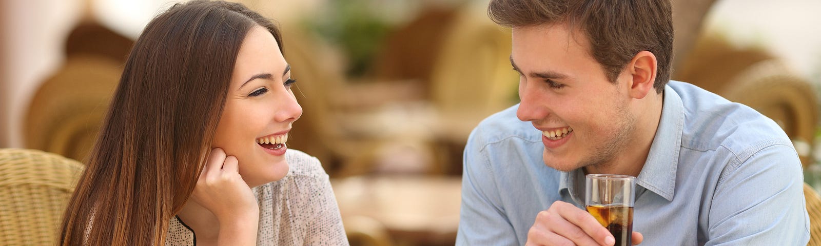 A man and woman enjoying a conversation and smiling (dating, conversation, communication skills, romantic relationships, sex and relationship studies)