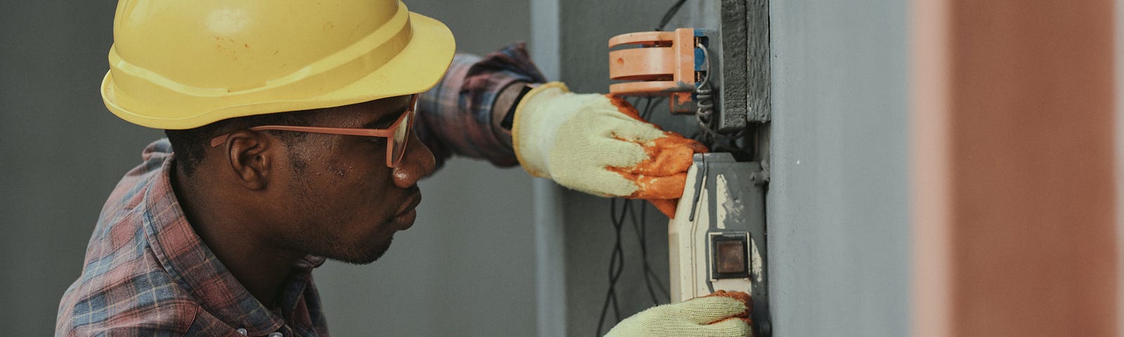 A man doing construction while wearing a hard hat.