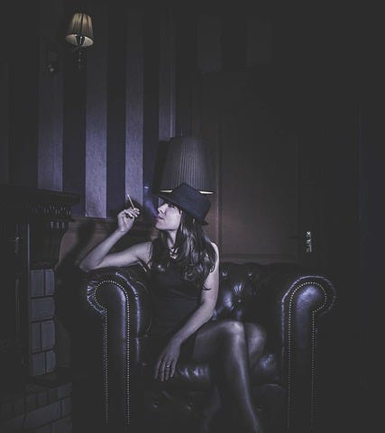 Young woman, Black hat, black dress, long hair, leather armchair, smoking, mood, pensive, sexy