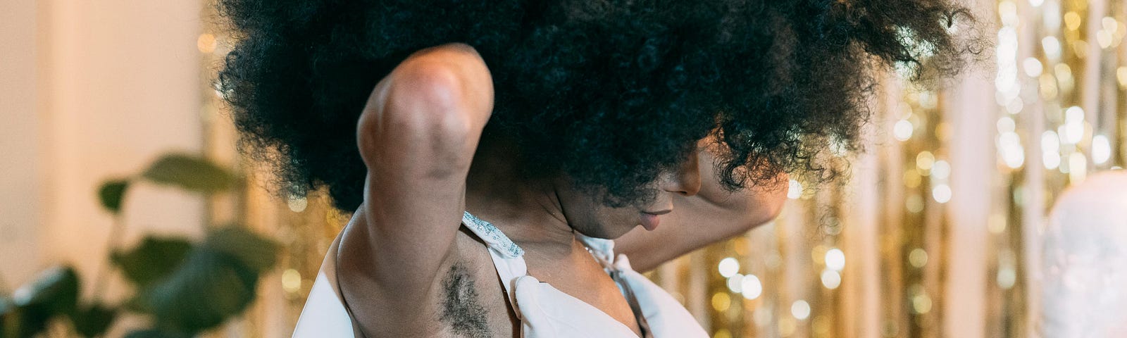 There’s a woman in a white dress. She has an afro and hairy armpits.