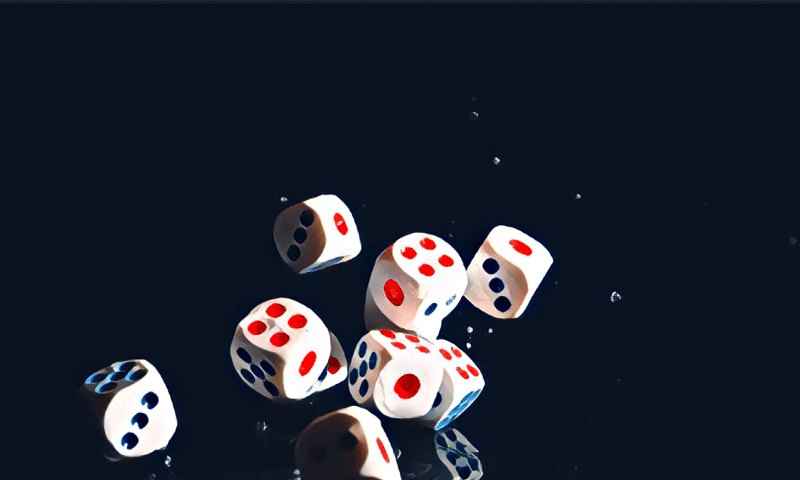 A black backdrop with dice tumbling surrounded by tiny particles