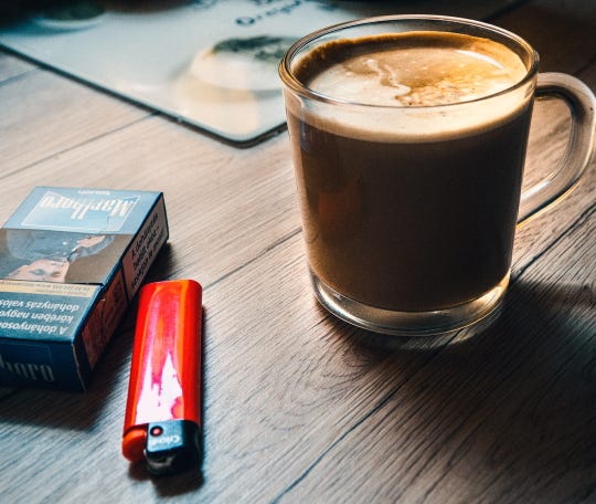 Cigarettes, red lighter and coffee., Unsplash photo cropped by author Graham D. Cooke.