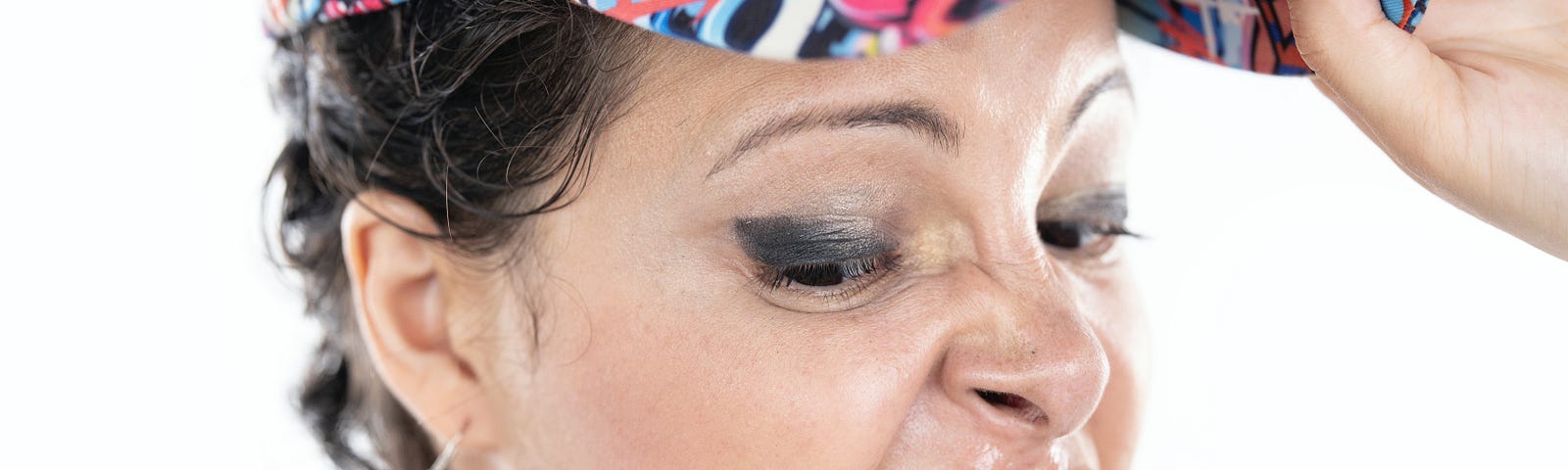 Close-up of a woman in a cap with a disgusted expression on her face.