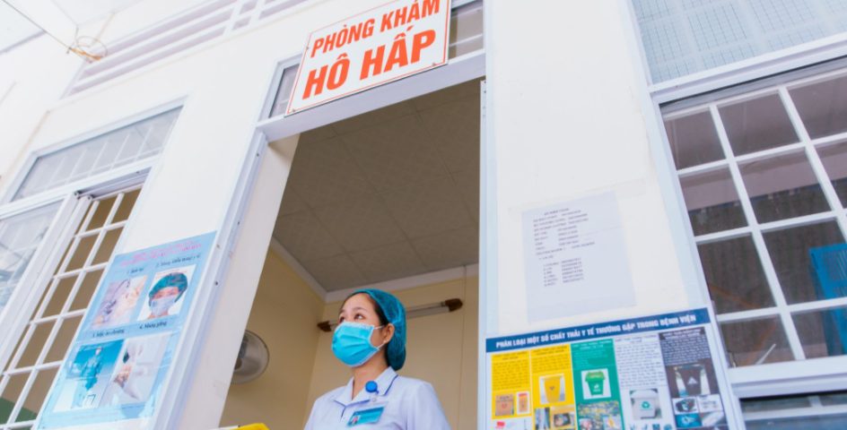 A healthcare worker stands outside a clinic in Vietnam.