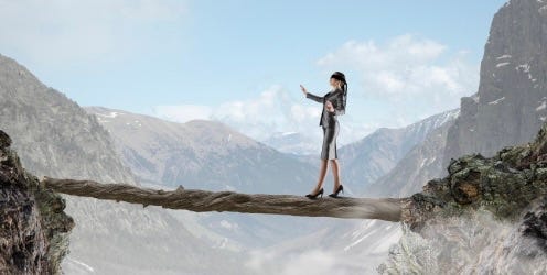 a woman in a suit is walking on a tightrope across mountains