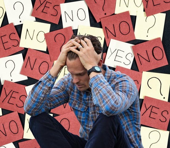 A man holding his head with both hands. The background is covered in Post-it with yes no, and question marks