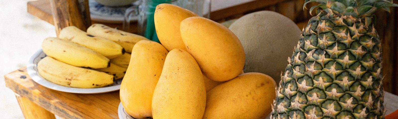 Bananas, mangoes, pineapple at a juice stand. Mangoes Not Folders by Jim Latham | Photo by Stephen Broome on Unsplash