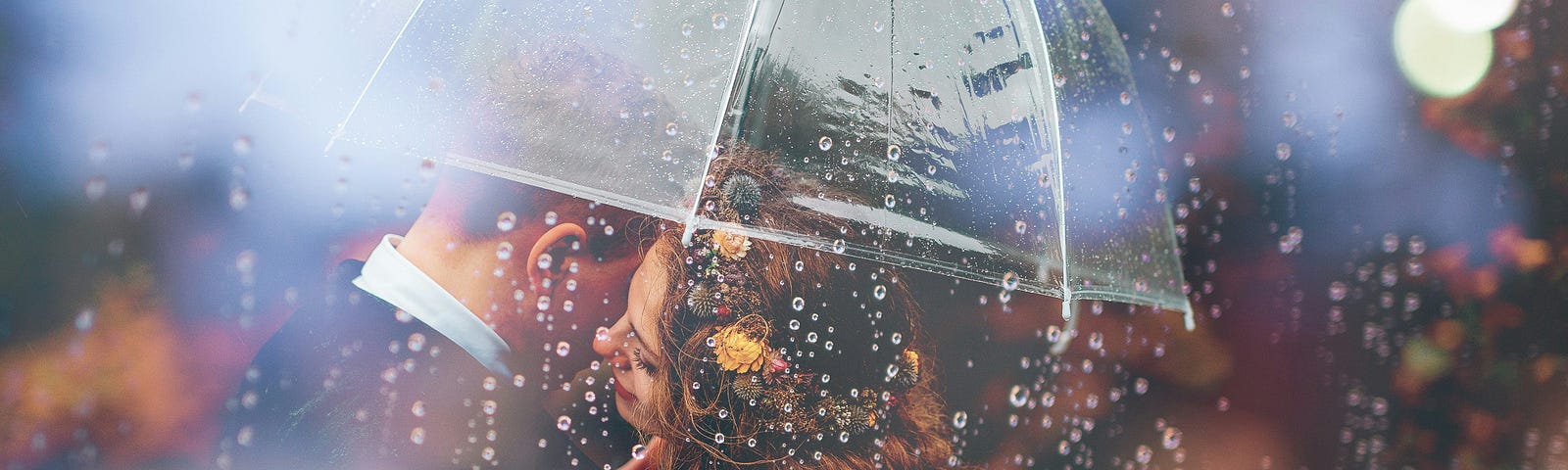 A bride and groom kiss each other under an umbrella