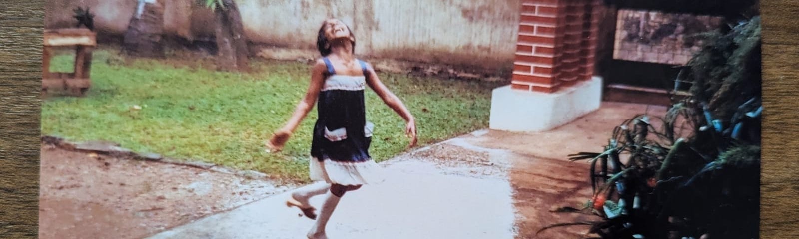Diliny as as child dances in the rain in her grandmother’s garden. A post-it stuck to the photo reads: She is happy today as she was yesterday.