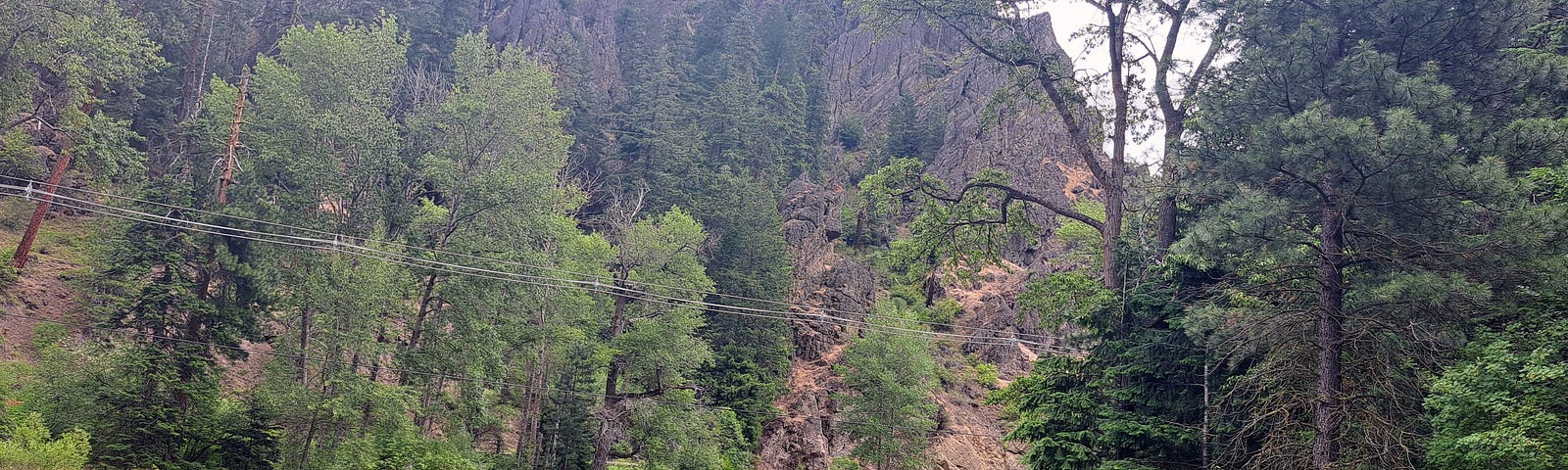 River, cliffs, trees, car in background