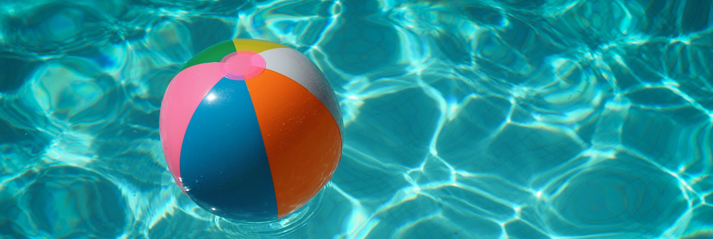 A colourful inflatable beach ball in a swimming pool