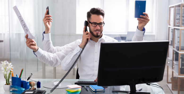 A four-handed male designer talking on the phone, holding a newspaper, a notebook, and a mobile phone.