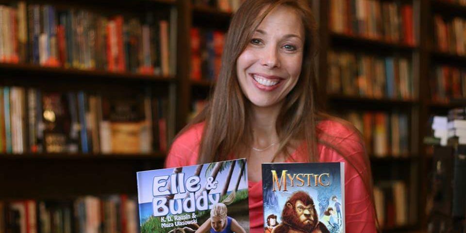 The author holding her picture book Elle & Buddy and her middle-grade novel Mystic.