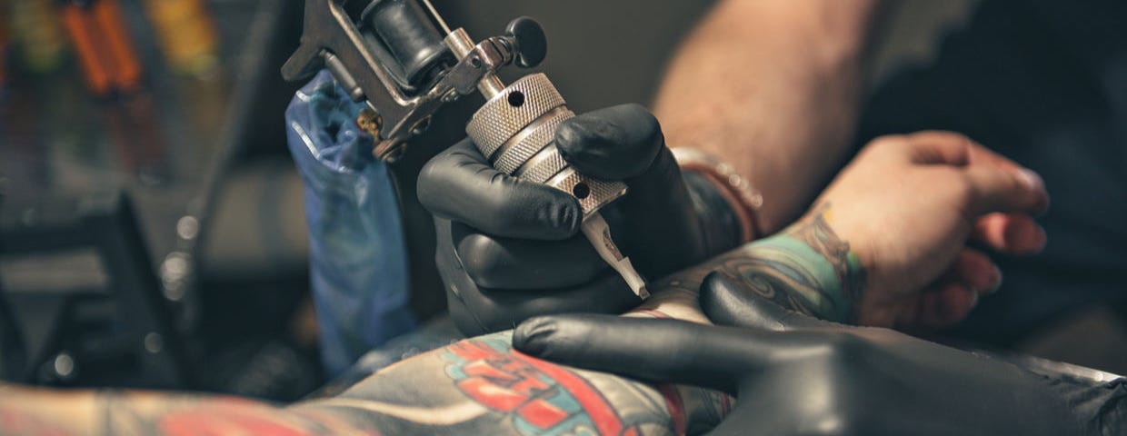 close up equipment for making tattoo art. Man doing picture on hand of woman