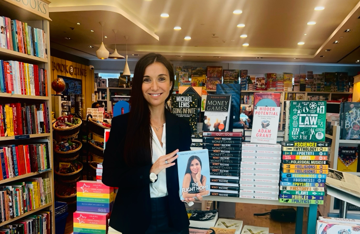 Picture of myself in black holding my book at a bookstore