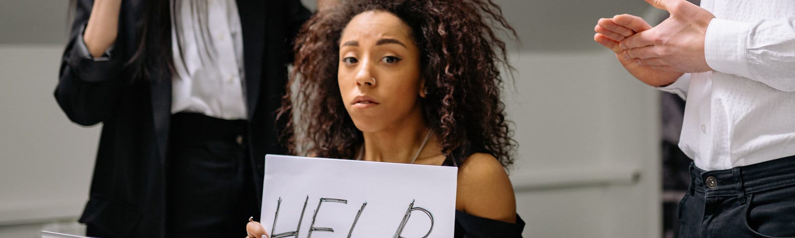 Woman holding a sign that say help.