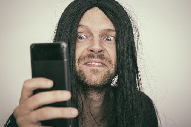 A man with a weird facial expression looking at his phone