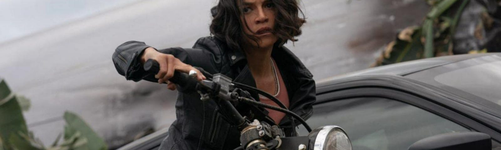 A woman with short hair rides a motorcycle