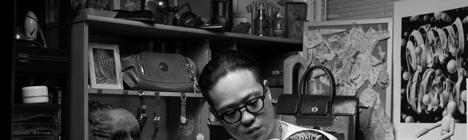 Photobook subject Vincent sitting in bedroom holding pet lizard