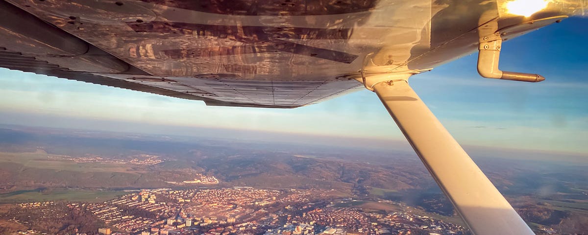 Photo of airplane over city.