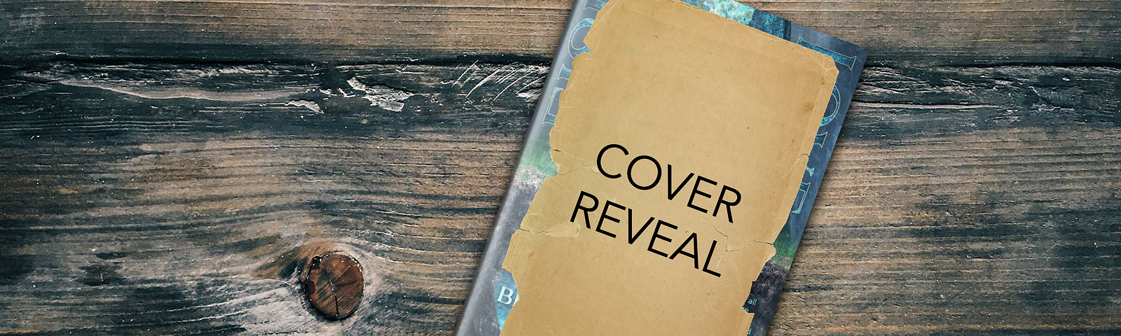 A book sitting on a wooden table. The cover of the book is covered with a piece of brown paper featuring the words “Cover Reveal.” The edges of the book cover can be seen around the edges of the paper, and the cover color is blue-green.