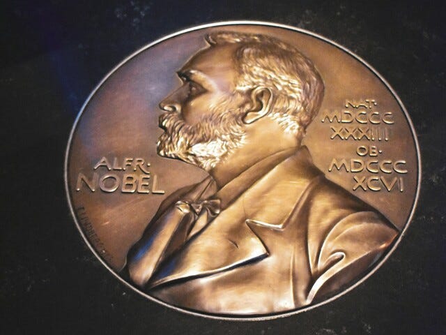 A gold coin with Alfred Nobel’s profile on it.